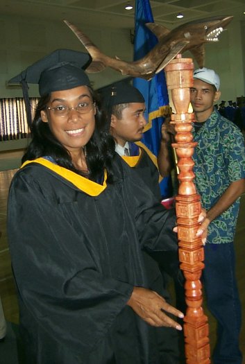 Phyllis Silbanuz carries the new College of Micronesia-FSM mace topped by the college mascot - a shark