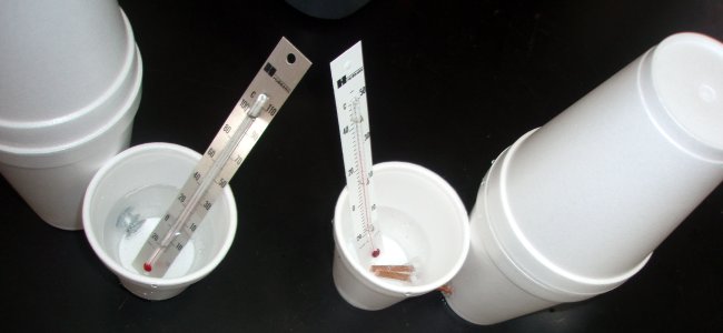 Metal is used to join two styrofoam cups of water together.